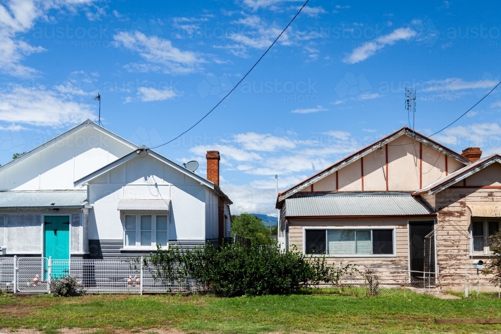 Newly painted house standing in contrast  beside an older house - Australian Stock Image