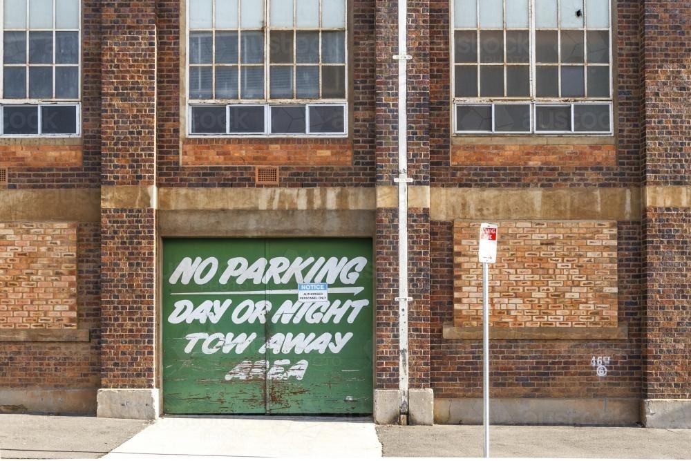 No parking sign on green door of historic factory in Launceston - Australian Stock Image