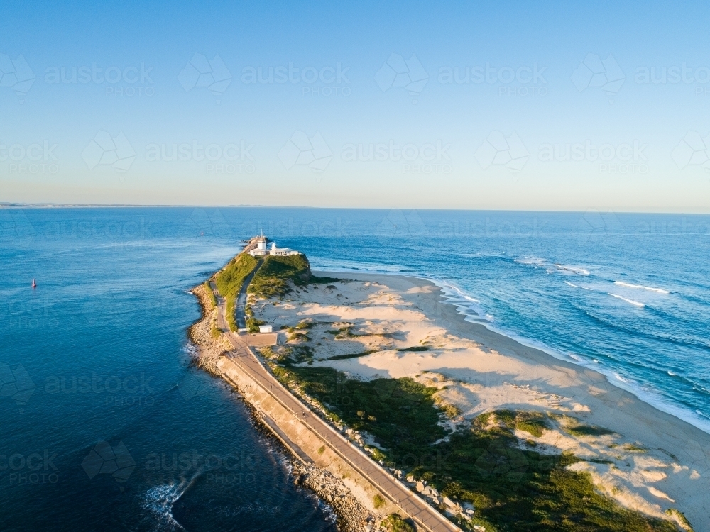 Nobbys beach headland and lighthouse in last evening light - Australian Stock Image