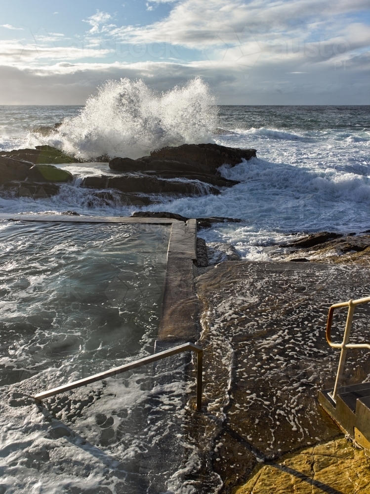 Ocean pool with waves crashing over rocks - Australian Stock Image