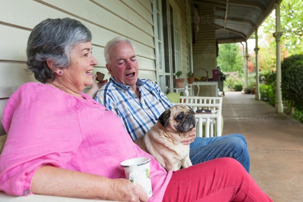 Image of Old couple sitting on the front porch with their pet dog ...