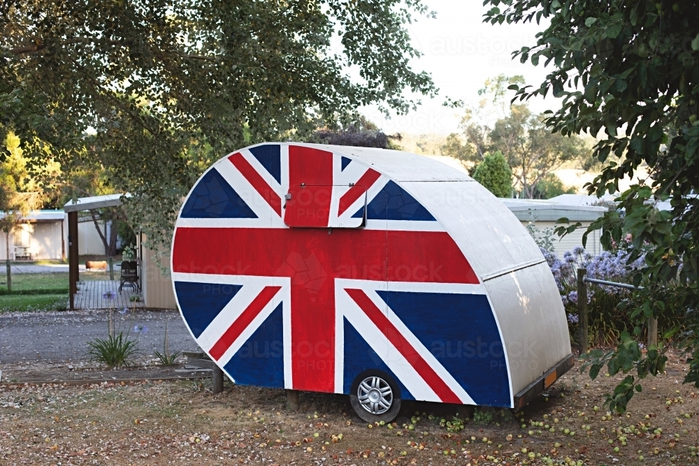 Old-fashioned caravan adorned with the Union Jack, symbolizing British pride - Australian Stock Image