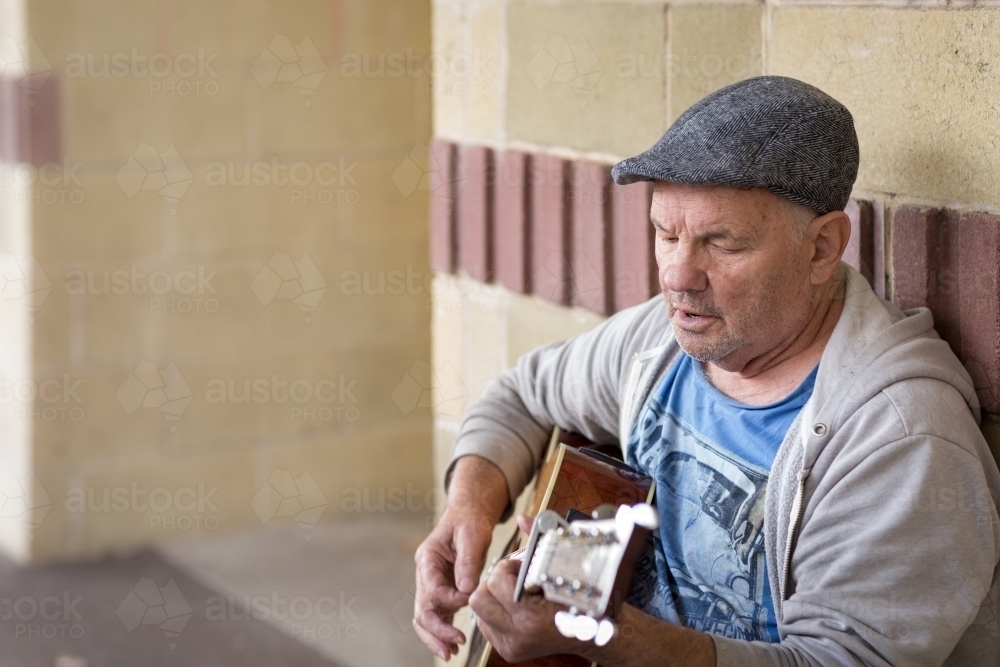 Old guy singing and playing guitar - Australian Stock Image