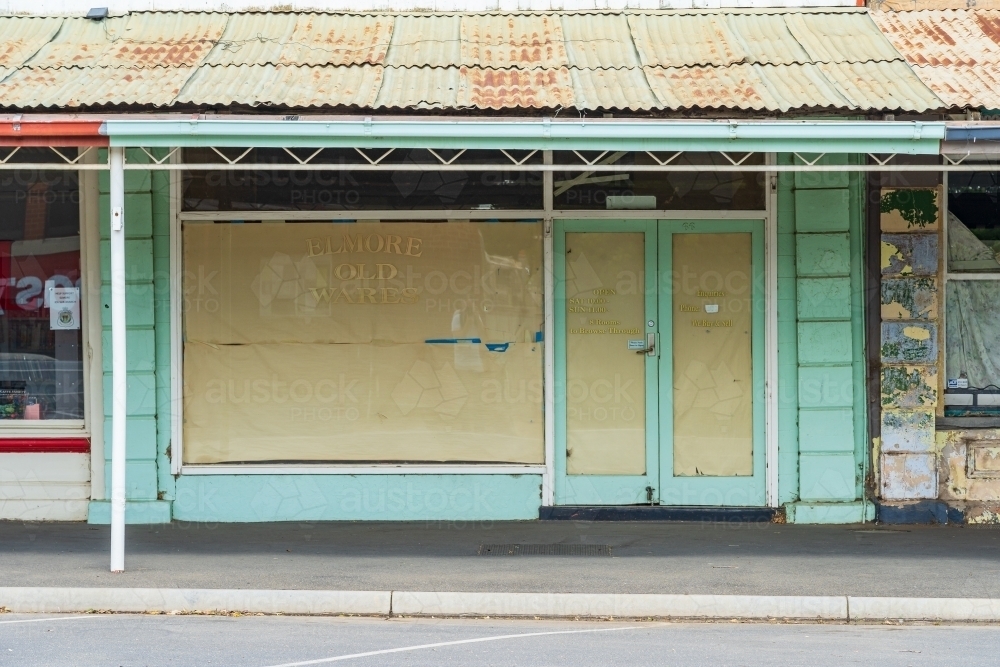 Old shopfront with paper covering its windows and a rusty tin veranda - Australian Stock Image