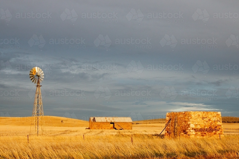 old stone farm buildings in golden light - Australian Stock Image