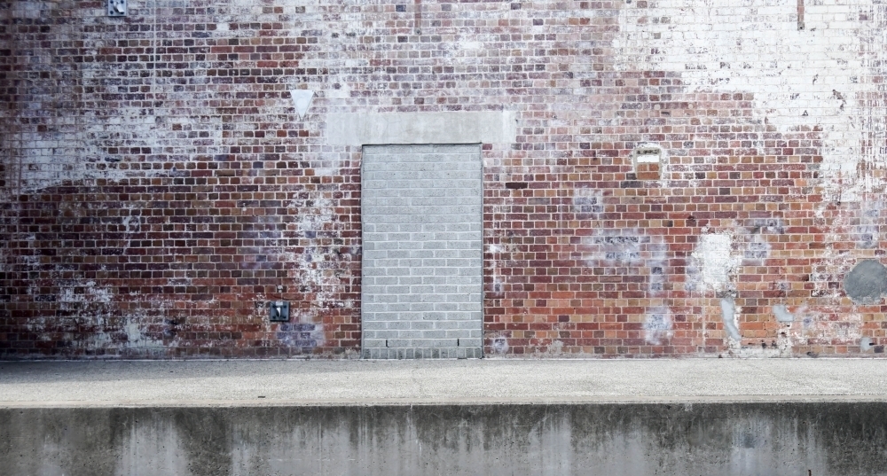 Old style brick wall with bricked up doorway - Australian Stock Image