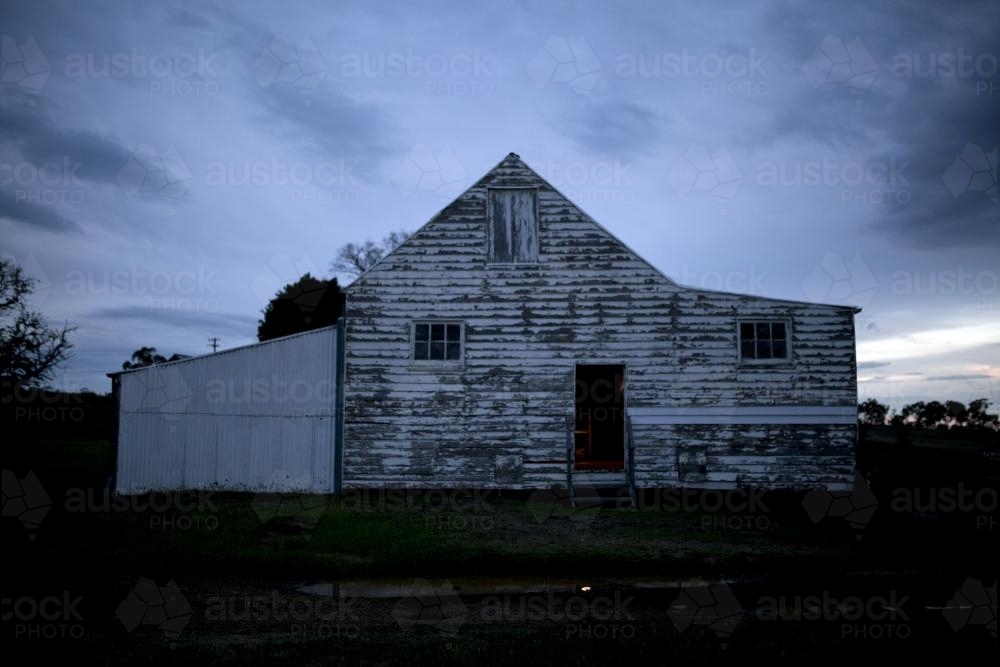 Old white wooden farm shed at dusk - Australian Stock Image