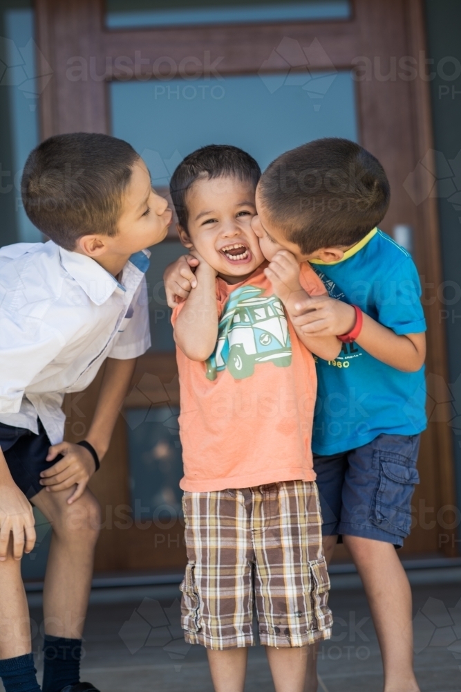 Older brother says goodbye to his siblings on his first day back at school - Australian Stock Image