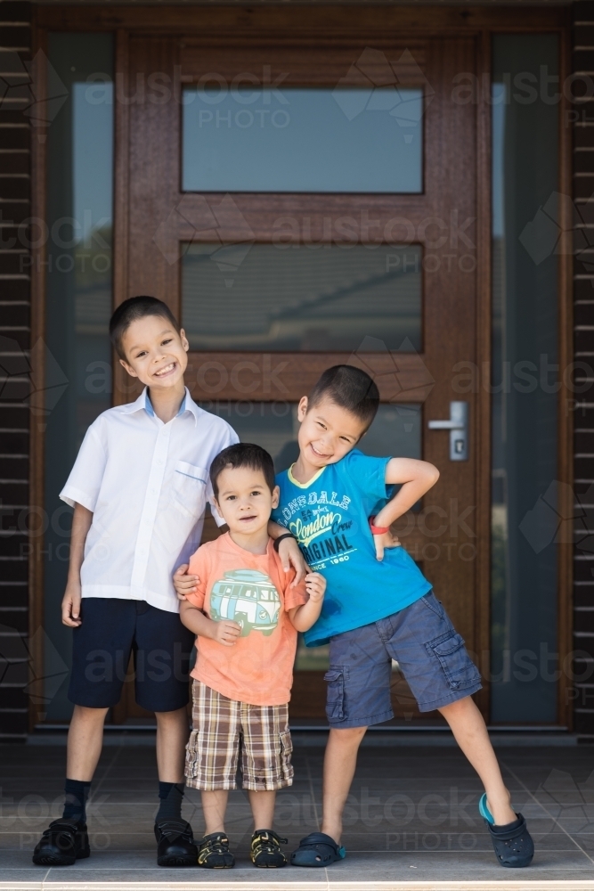 Older brother says goodbye to his siblings on his first day back at school - Australian Stock Image