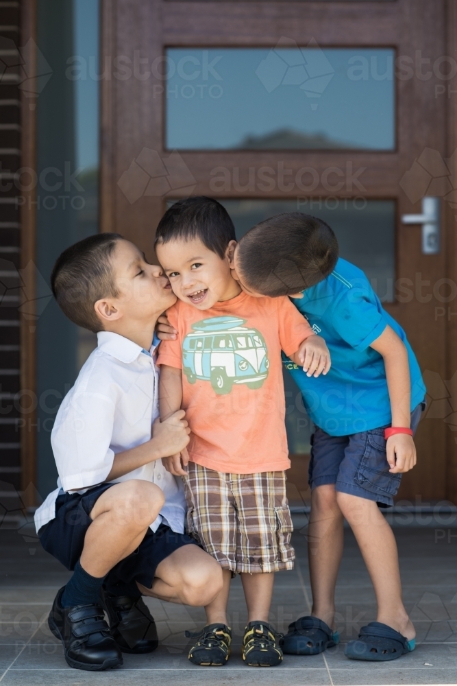 Older brother says goodbye to his siblings on his first day back at school - Australian Stock Image