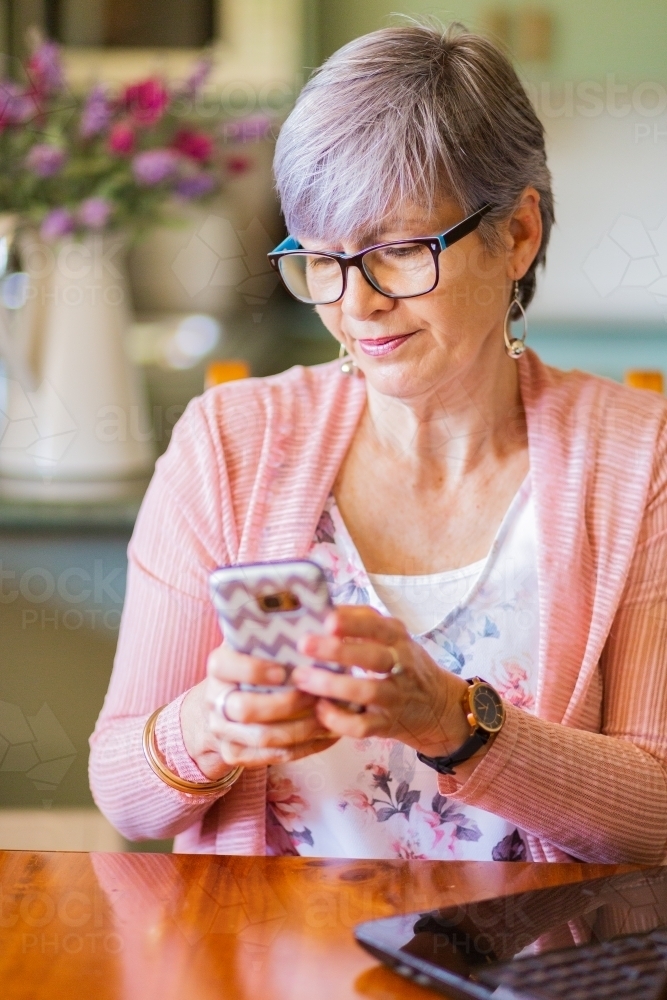 Older female person texting with mobile phone - Australian Stock Image