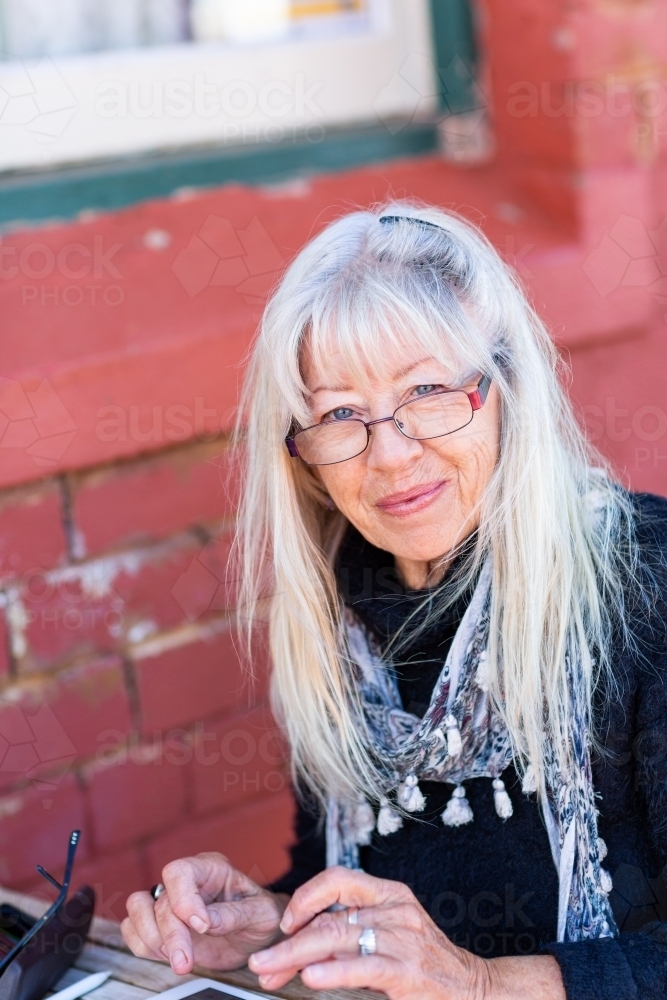 older lady looking at  camera over rim of glasses - Australian Stock Image