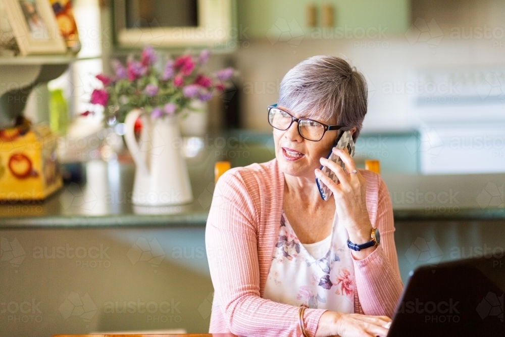 Older woman struggling using laptop technology - Australian Stock Image