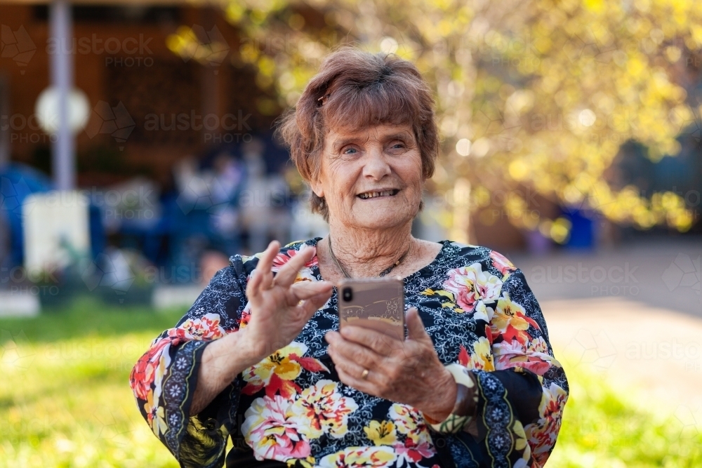 image-of-older-woman-using-technology-outside-in-her-backyard