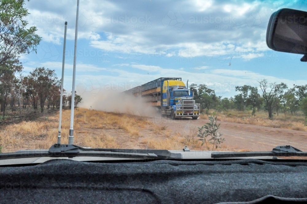 oncoming road train on a dirt road from inside the car - Australian Stock Image