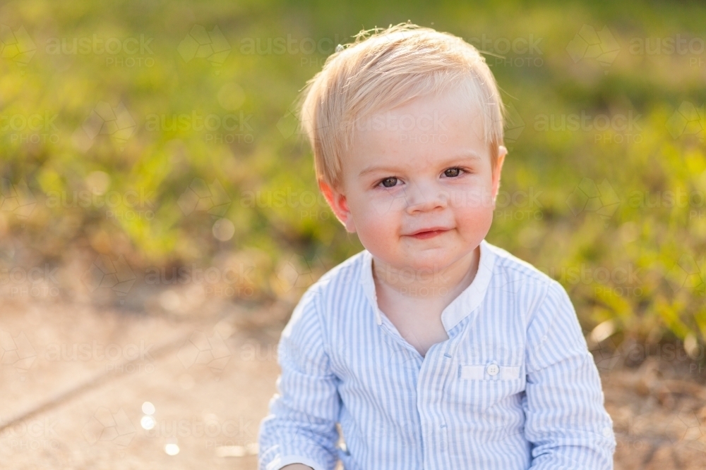 image-of-one-year-old-boy-sitting-on-footpath-backlit-by-evening-light