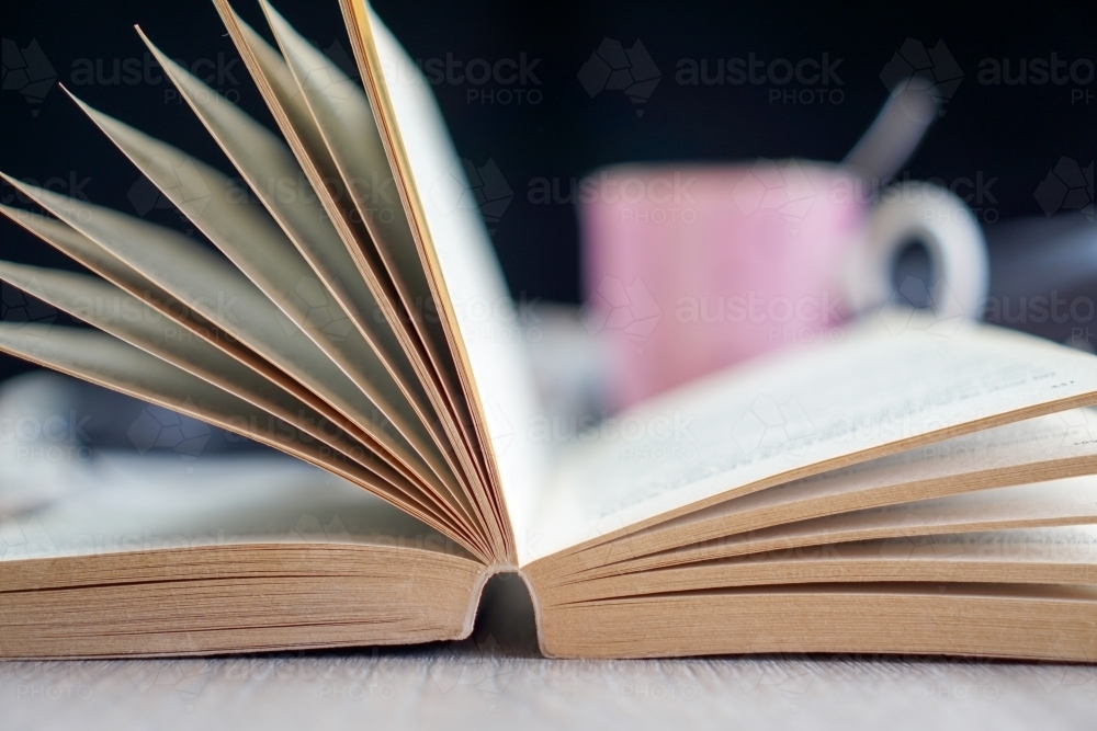 Open book with coffee cup in background - Australian Stock Image