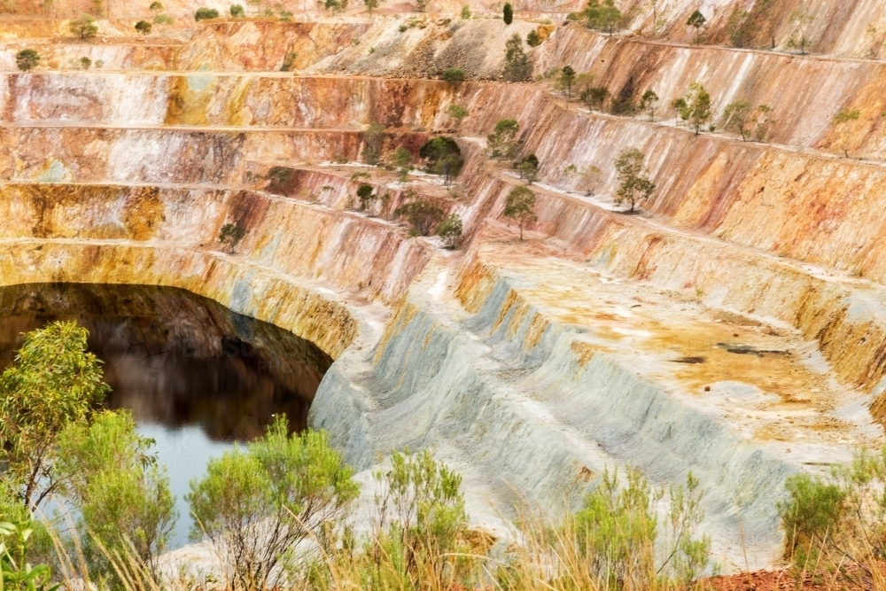 open cut mining with rusty environment and some grass in random places - Australian Stock Image