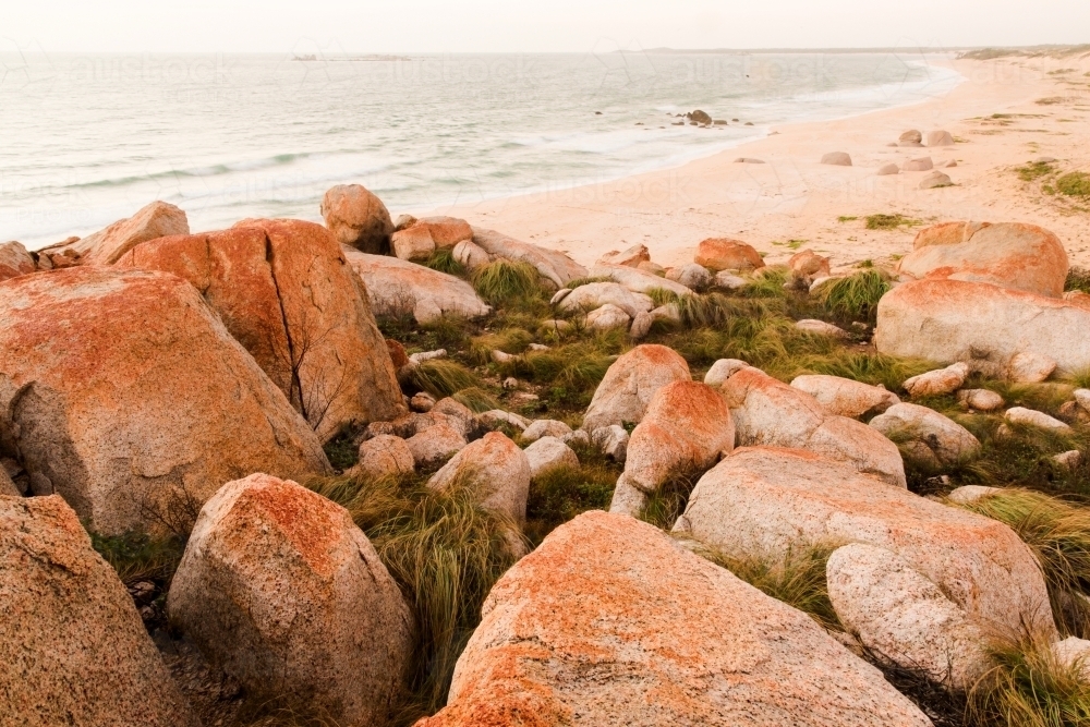 Orange coloured rocks on a beach - Australian Stock Image