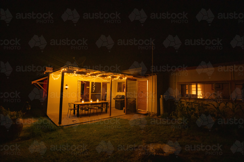 Outdoor patio of rural farm house lit up at night with fairy lights - Australian Stock Image