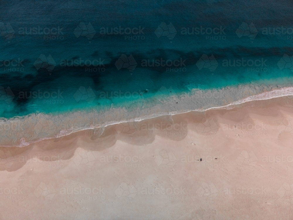 Overhead aerial shot of ocean waves on sandy beach - Australian Stock Image