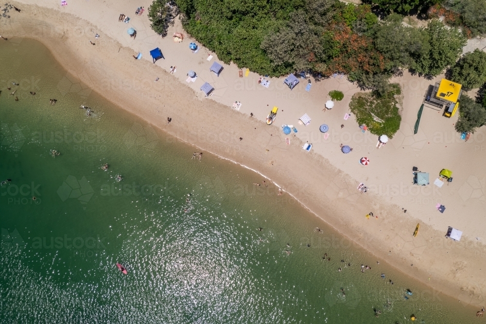 Overhead view of busy beach day for sunbathers and beach patrol - Australian Stock Image