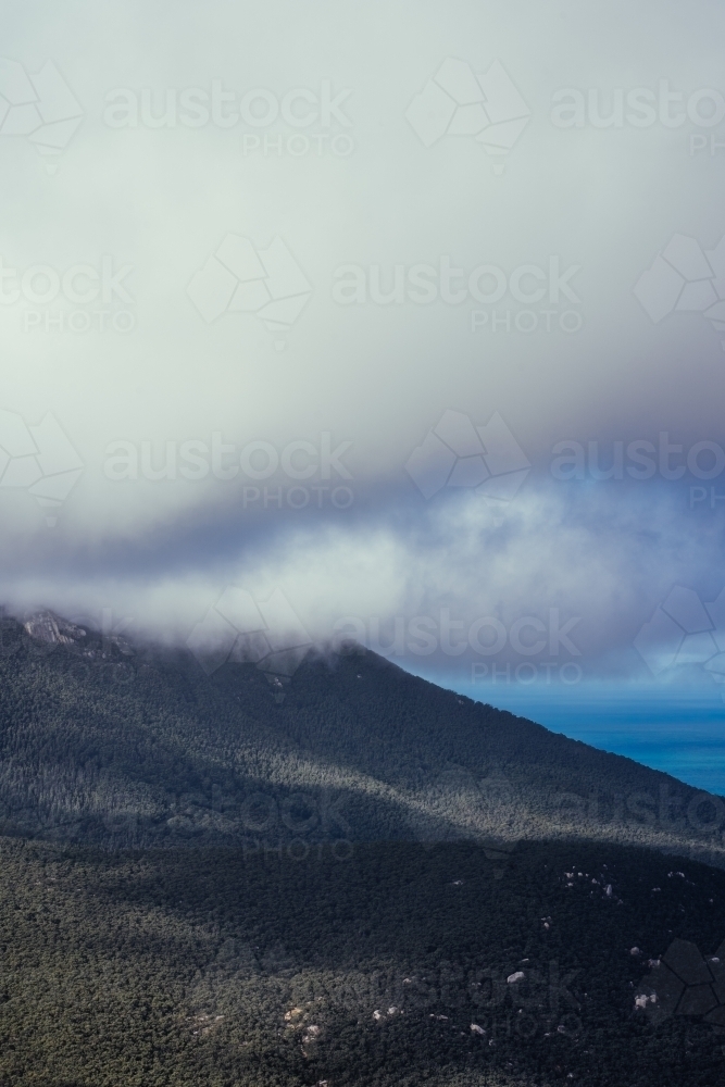 Overlooking rock formations and open sea in Victoria shrouded with clouds - Australian Stock Image