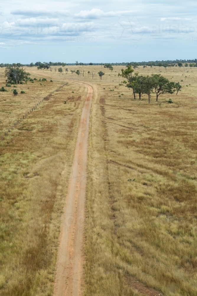 Paddock and dirt road on farm. - Australian Stock Image