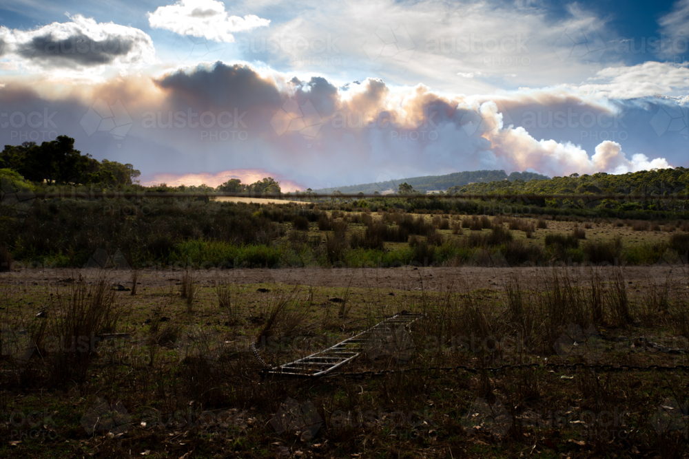 Paddock on rural afternoon with bushfire smoke on horizon - Australian Stock Image