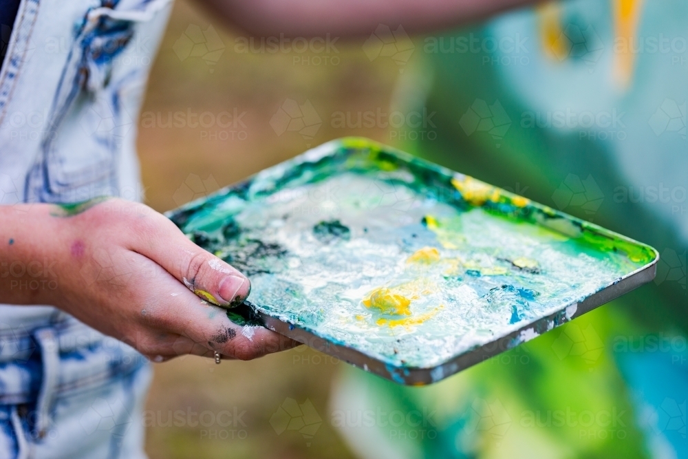 Paint tray for mixing colour in artists hand - Australian Stock Image