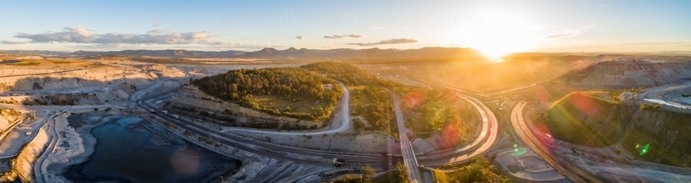 Panoramic aerial view of open cut coal mines surrounding road in Singleton area - Australian Stock Image