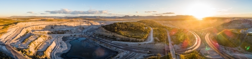 Panoramic aerial view of open cut coal mines surrounding road in Singleton area - Australian Stock Image