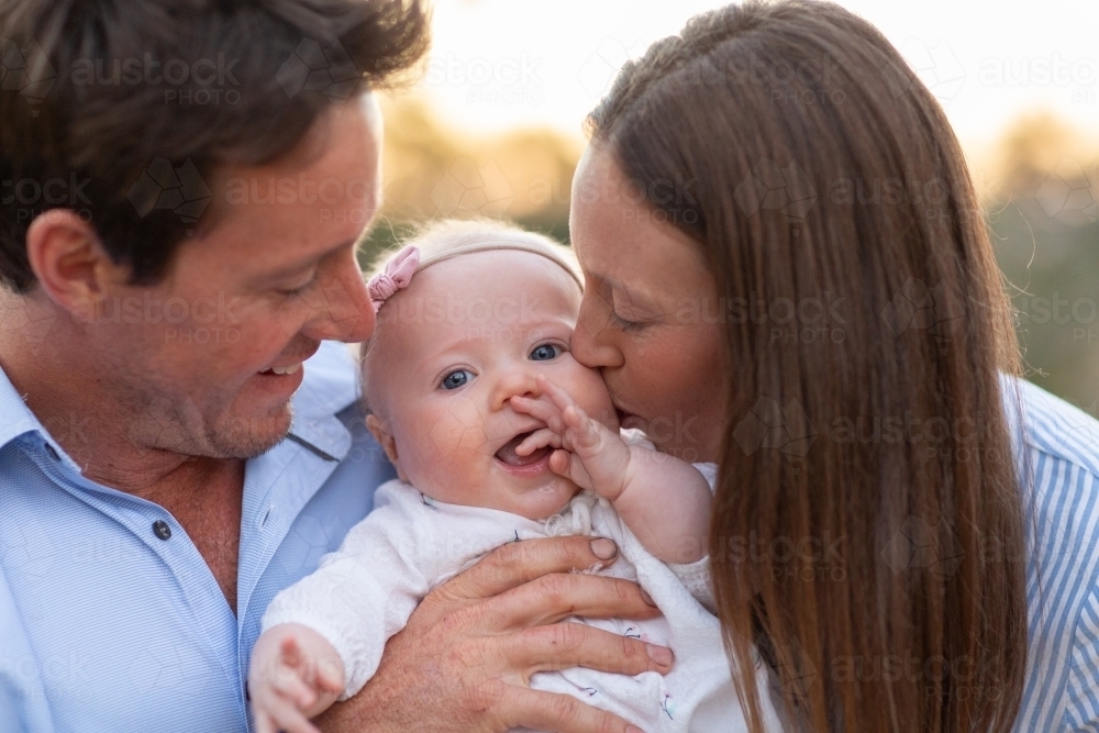 Parents cuddling their baby girl - Australian Stock Image