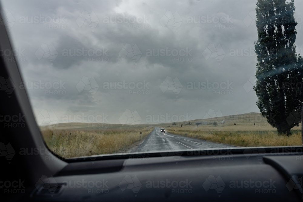 Passenger POV through windscreen / windshield of oncoming ute driving on Australian rural, dirt road - Australian Stock Image