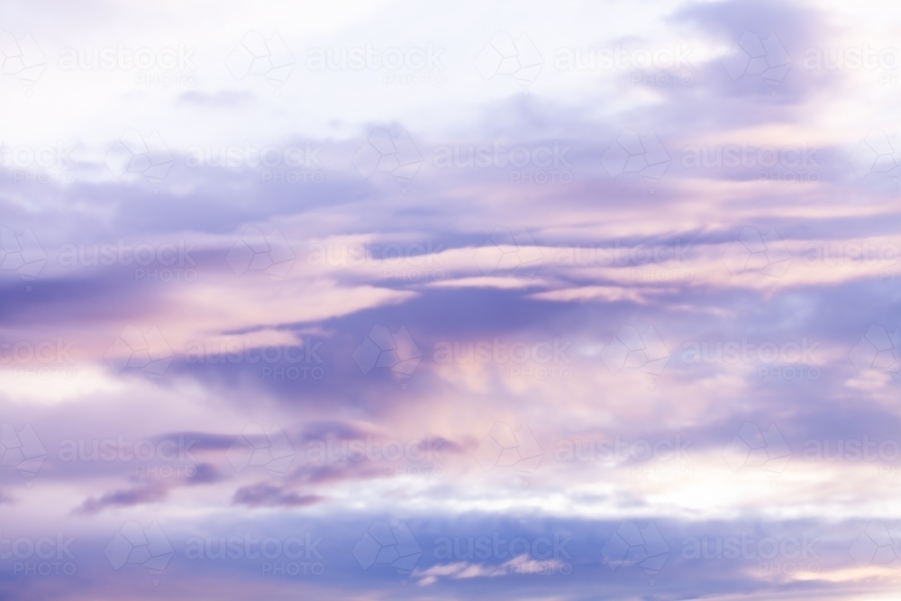 pastel purple and pink clouds in sky at dusk - Australian Stock Image