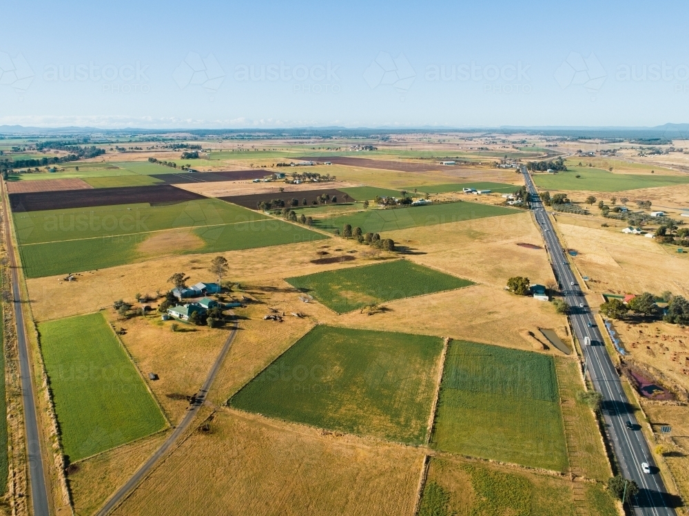 patchwork of farm paddocks beside highway - Australian Stock Image