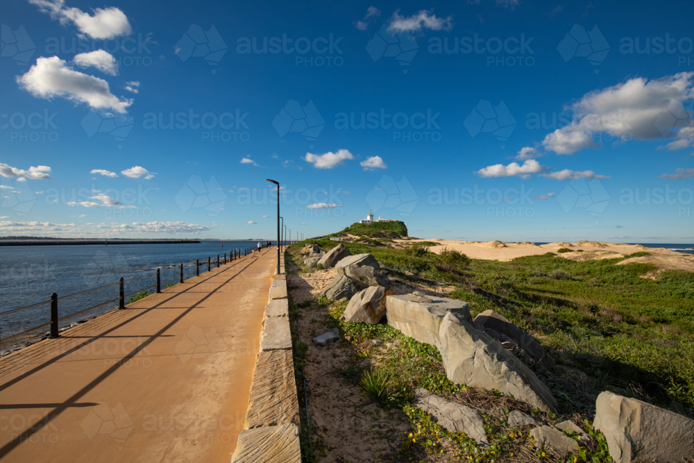 Path along the Newcastle Breakwater leading to Nobbys Lighthouse - Australian Stock Image