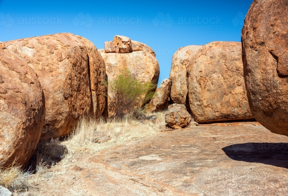 Pathway to large rock formations sitting next to each other. - Australian Stock Image