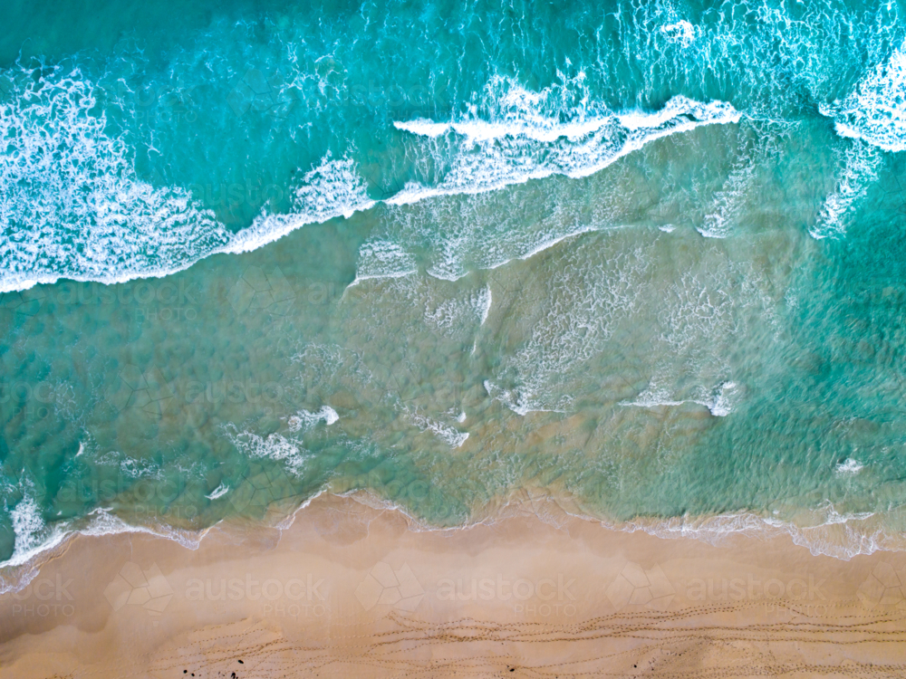 Patterns emerge as waves make way to the shoreline - Australian Stock Image