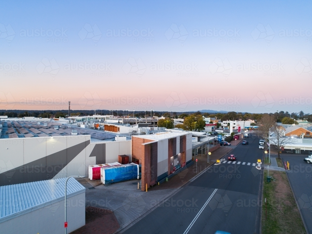 Pedestrian crossing between carpark and shopping centre in town at dusk seen from aerial view - Australian Stock Image