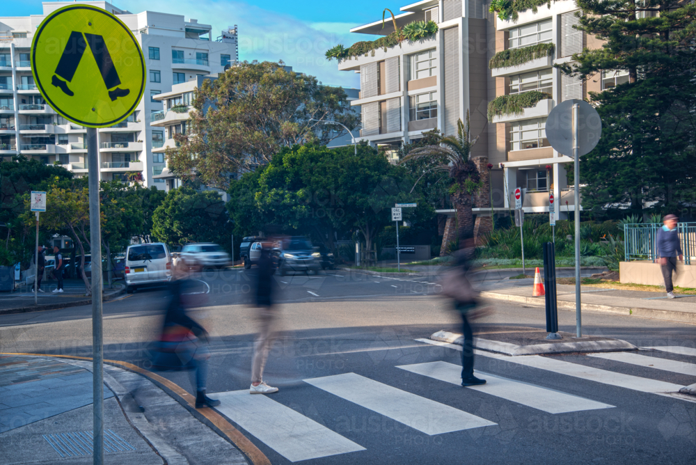 Pedestrian crossing with blurry pedestrians walking across it - Australian Stock Image