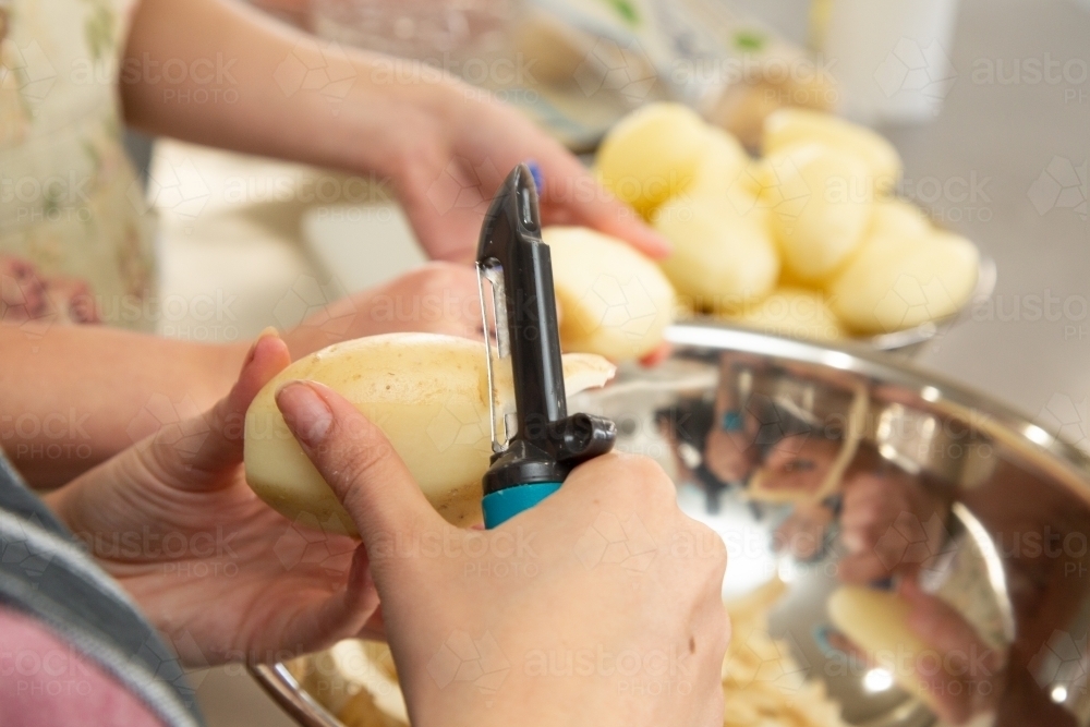 Peeling potatoes for cooking - Australian Stock Image