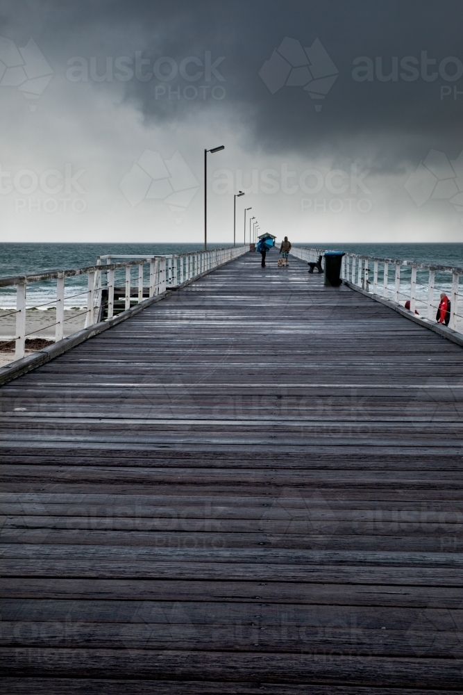 People on jetty on a stormy day - Australian Stock Image