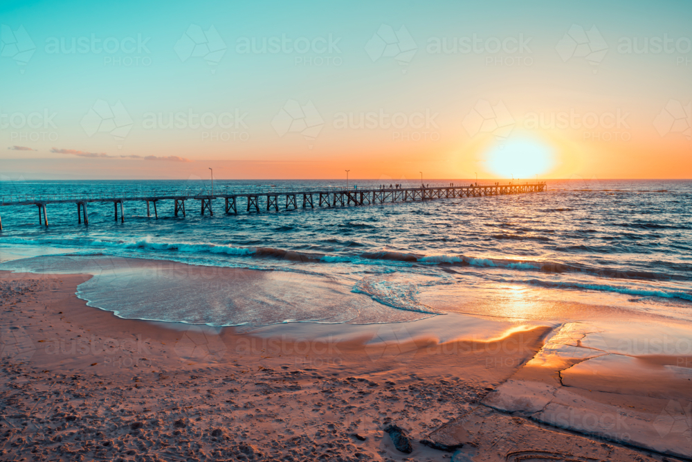 People silhouettes on Port Noarlunga jetty at sunset, South Australia - Australian Stock Image
