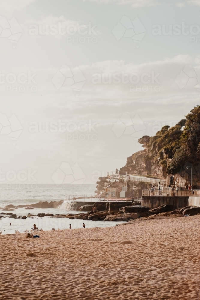 People swimming at the Bogey Hole and Bronte Ocean Pool (Bronte Baths) at sunrise vertical - Australian Stock Image