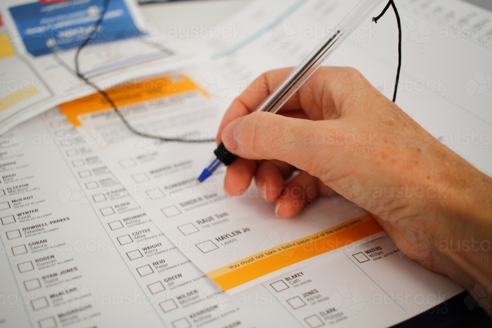 person filling out voting ballot paper forms for election - Australian Stock Image