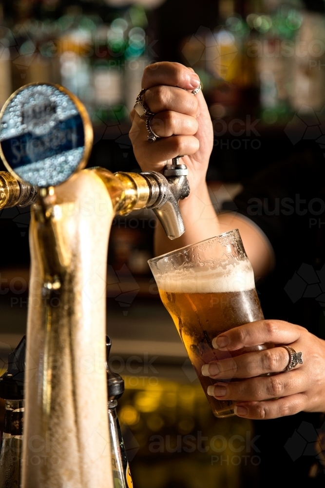 Person pouring a beer in a pub - Australian Stock Image