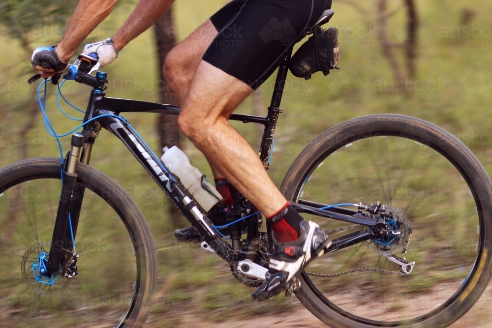 Person riding push bike on mountain bike track in the bush - Australian Stock Image