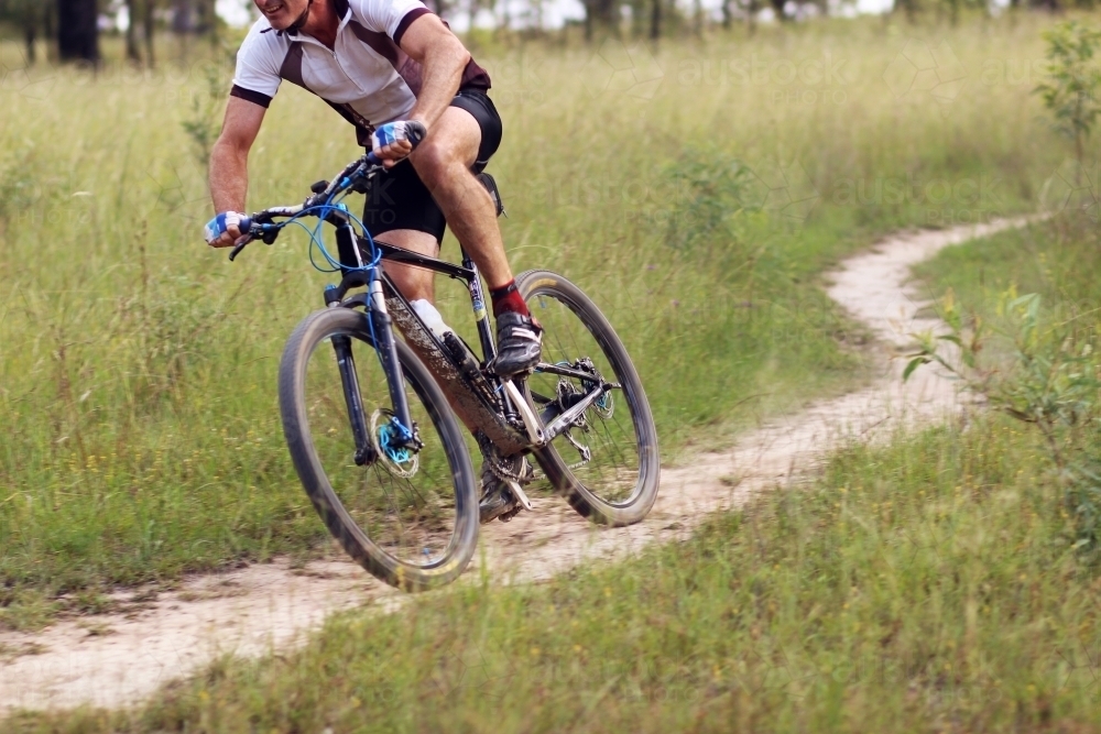 Person riding push bike on mountain bike track in the bush - Australian Stock Image