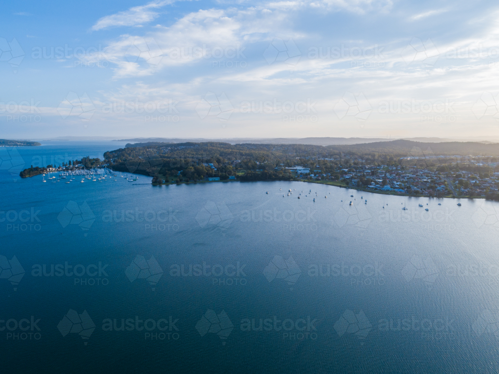 Personal recreational boats and yachts moored on distant shore of Cockle Bay in Lake Macquarie - Australian Stock Image